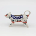 Ceramiczny mlecznik krowa z wylotem w pyszczku.