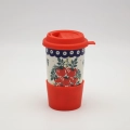 Ceramiczny kubek na kawę do samochodu Bolesławiec w uchwycie na kubek na desce rozdzielczej.