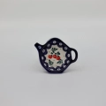 Ceramiczna podstawka na torebkę herbaty z ręcznie malowanym motywem dekoracyjnym.