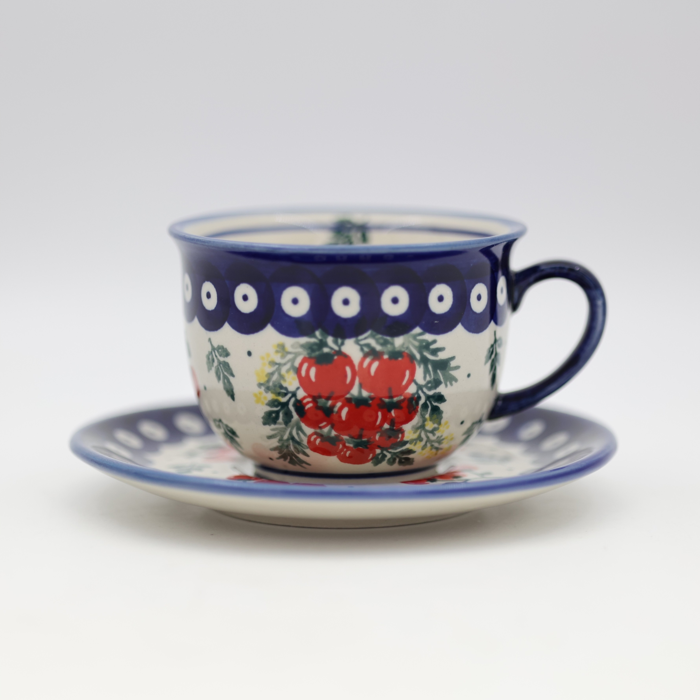 Ceramiczna filiżanka ze spodkiem do kawy z Bolesławca z ręcznie malowanym zdobieniem.
