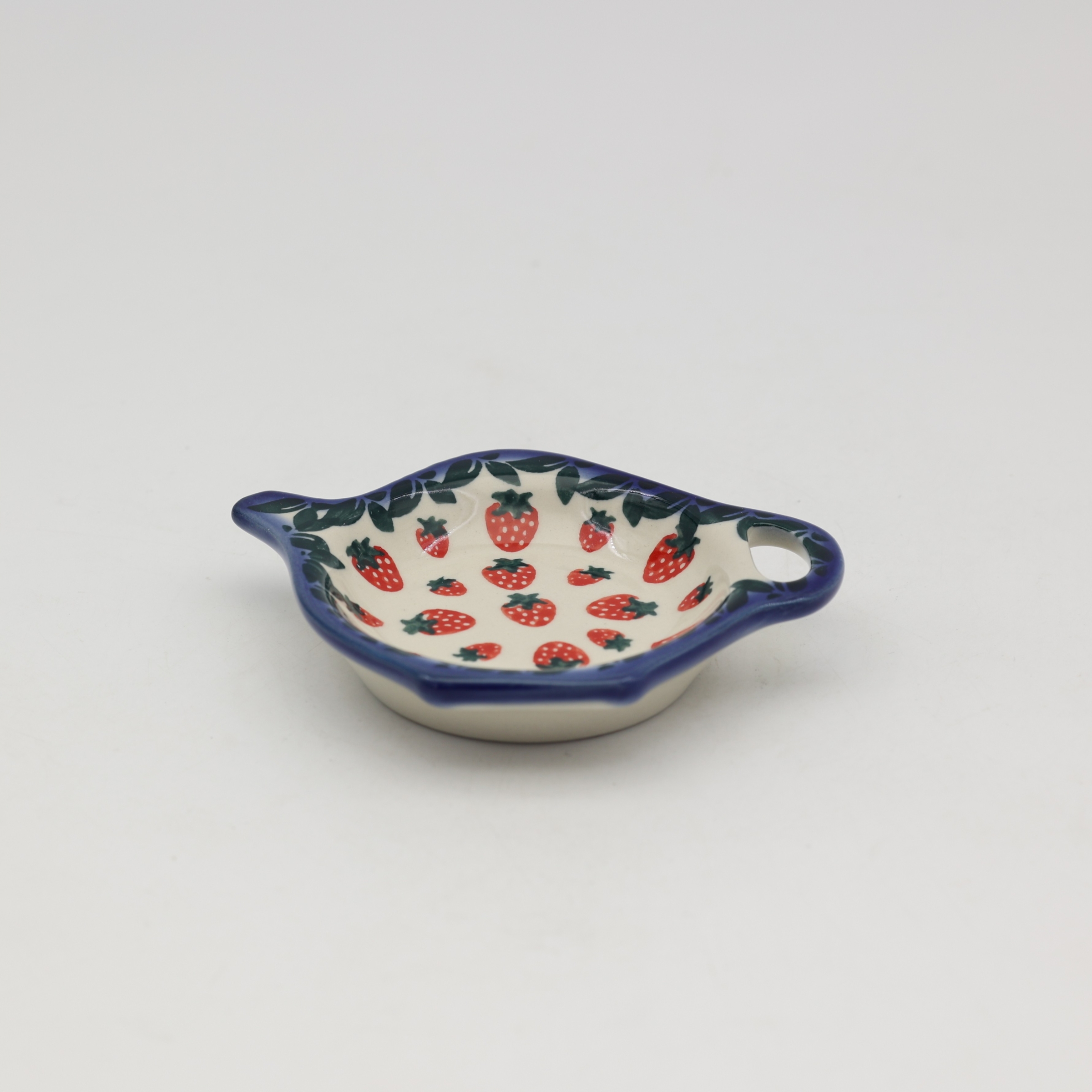 Ceramiczna podstawka z odłożoną torebką herbaty.