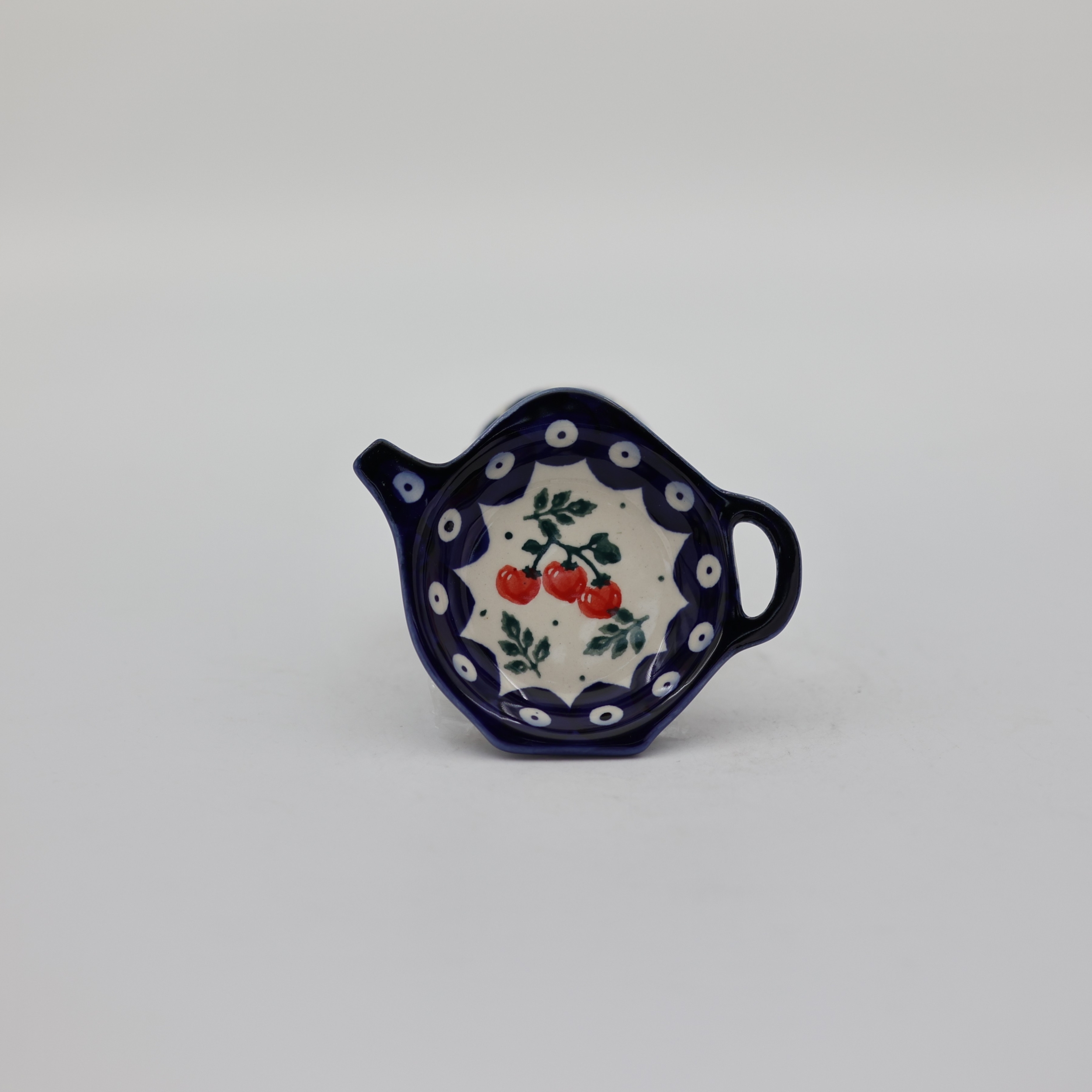 Ceramiczna podstawka na torebkę herbaty z ręcznie malowanym motywem dekoracyjnym.